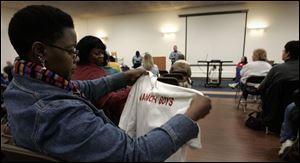 Yulanda McCarty-Harris looks over a Manor Boys gang T-shirt during the 6th annual Parents' Summit at Waite Brand Auditorium on Summit Street. About 75 parents attended the event.