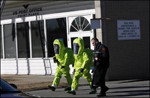 Firefighters in HAZMAT suits monitor the air outside the post office in Point Place.