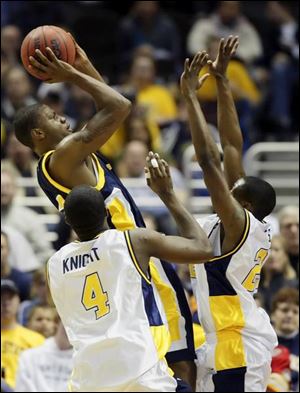 Toledo's Keonta Howell shoots over Kent State's Issac Knight, left, and Armon Gates during the first half of the MAC tournament final in Cleveland. Howell finished with seven points. The Rockets were down 18 points but rallied to within three in the second half.
