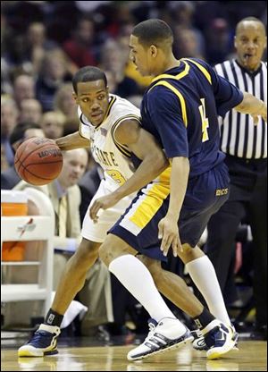Toledo's Jonathan Amos tries to get by Kent State's DeAndre Haynes last night in the MAC tournament championship game. The Rockets, who started the MAC season 1-6, are 20-11 overall and hoping for a bid to the NIT.