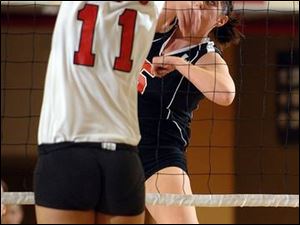 East Kentwood's Lauren Jones spikes the ball through the arms of Bedford's Amy Zuccarell (11). Jones had 20 kills. By DONALD EMMONS