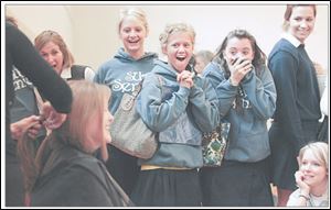 Students at St. Ursula Academy watch as classmate Mary Kenney gets more than 10 inches of her locks shorn to be used in wigs for children with long-term medical hair loss.
