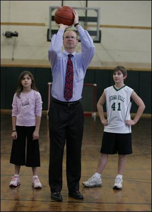 Daryl Moreau shows his children, Hannah and Adam, how to shoot free throws. He's an expert. Moreau hit 126 in a row when he played at a New Orleans high school.