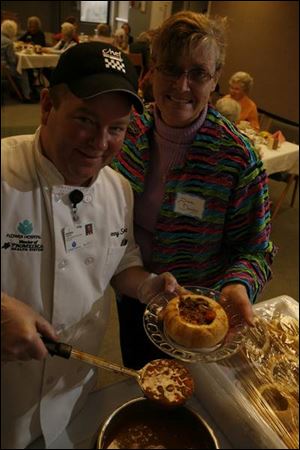 Chef Dennis Seibert of Flower Hospital serves Poor Man's Steak Soup in a bread bowl to Diane Dooley during an auxiliary meeting. Catering special events can be part of hospital chefs' duties.