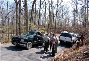 Offi cers from the Tennessee Wildlife Resources Agency gather near the Chilhowee campground where a black bear mauled three members of a family from Clyde, Ohio, on Thursday.
