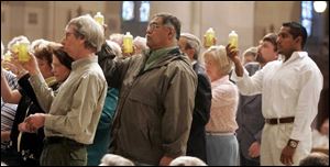 Oil of Catechumens is presented by parish representatives for blessing.