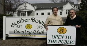 Joe Garverick, left, one of the new Heather Downs owners, and general manager Dan Hathaway show a sign of the times. The club, which opened in 1925, was private until this year. 


