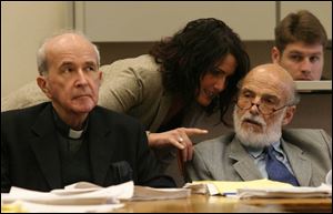 Rev. Gerald Robinson, left, and attorneys John Thebes and Nicole Khoury listen today. 