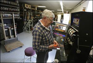 Paul Myers ponders a repair on a slot machine at the Delaware Avenue firm, which sells about 1,000 machines a year.