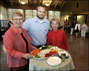 Judy Westmeyer, left, Chris Smalley, and Joanie Foster share hors d oeuvres in the Nature Preserve s Nature Center.