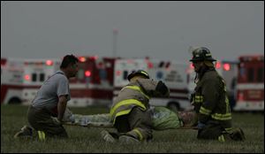 Firefi ghters hone their skills during a disaster drill by practicing treating the injured.
