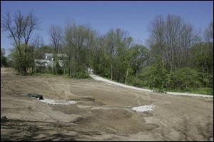 The white Lathrop House overlooks a ravine that has been cleared to make way for a pond in Sylvania.
