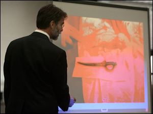 Assistant prosecutor Dean Mandros shows the suspected murder weapon displayed on the altar cloth and the matching blood stain to the jury in Lucas County Common Pleas Court.
