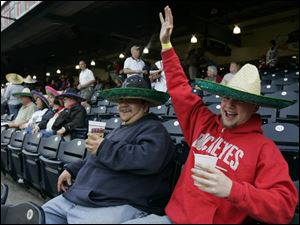 Mud Hens fans Chris Morales, above left, and Dan Wagner, both from Toledo, cheer as the team enters
the field last night. They were among the first 1,000 fans given free sombreros in celebration of Cinco de Mayo.
