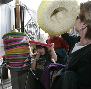 Jennifer Frantz, left, chooses a fuchsia-rimmed sombrero before heading into the stadium. Last night s plans also included a fireworks display, and hundreds of Scouts
had signed up to camp overnight on the field. 