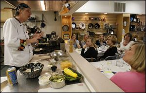 Chef Geoffery McKahan teaches a private cooking class to a mother's group at Essential Gourmet.