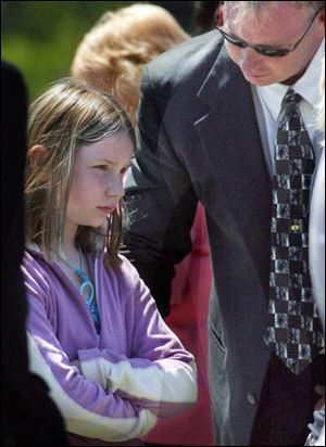 A young mourner looks on as Lauren Sanders, 10, and her 5-year-old brother, Jacob, are buried in Swanton.