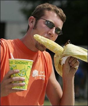 Brandon Butler of Bowling Green enjoys some lemonade and an ear of corn at the 2005 Wood County Fair. 