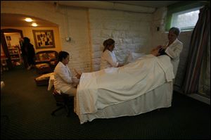 Patty Flanagan receives a simultaneous foot, hand, and scalp massage from Nikki Soto, left, Angie Sifuentes, center, and Jan Archambeau at The Kerr House in Grand Rapids, Ohio. 