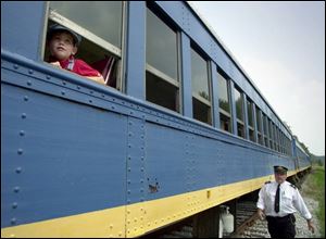 TLE&W chief Bill Linebaugh, strolls down the tracks next to the Waterville-based Blue Bird. 