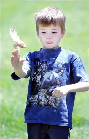 Ethan Cole, 7, of Maumee, throws a dart made from corncobs and feathers.