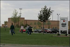 A family attending a high school baseball game walks past a sign touting the Archbold Local School District's state ranking of Excellent. The district's board of education unanimously agreed to ask voters to approve a 9.78-mill emergency levy to fund school operations. The district's previous levy request failed at the ballot box on May 2.