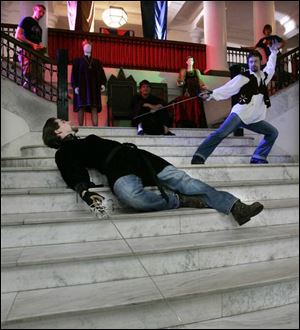 Ryan Zarecki, lying down, as Laertes, and Danny Patton as Hamlet rehearse a sword fight scene in BGSU's University Hall. The class replicates the experience of a film production crew. 
