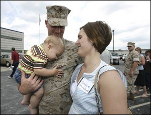 Lance Cpl. Matthew Strecker of Monroeville, Ohio, hugs his 10-month-old son, Nicholas, and wife, Stacie, as his Marine Corps Reserve unit based in Perrysburg Township prepares for deployment.