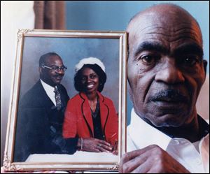 Charles Johnson in mid-1996 holds a photograph of himself and his wife, Jeanette Johnson, who was killed by Johnnie Jordan in January, 1996. Mr. Johnson died 11 months after her.