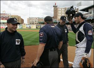 Glad to see the umps? You bet. Hens catcher Max St-Pierre
greets regular umpires R.J. Thompson, left, and Chris Hubler.
