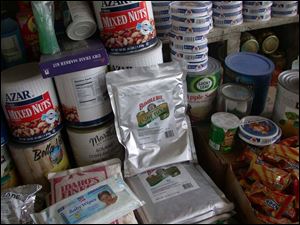 A grocery shelf at a bazaar shop contains foil packets of tuna and other smuggled American goods.