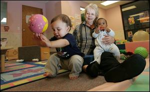 Toledo Day Nursery's Executive Pat Scheuer with Adrien Urbina, 13, months, and Je-dyn Williams, 9 months.