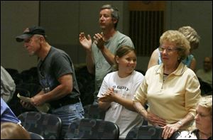 Larry Fey, his granddaughter Megan Howard, and Betty Erdmann, front row, applaud the demise of the proposed bike path, which would have wound through their neighborhood.