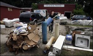 Tim Krop helps clean up debris at a business in Norwalk. Last week's storms flooded about 800 homes in Huron County. More rain is in the forecast for Norwalk today and tomorrow.