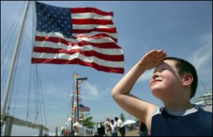 Treyton Scherz, 6, of Sandusky shades his eyes against the sun as he views the goings-on in Sandusky Bay, where the city is sponsoring a tall ships display at the Meigs Street Pier.
