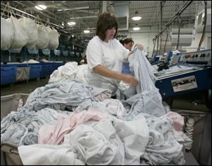 At the Gibsonburg laundry plant, Tina Rodriguez folds her way through a small island of clean towels. 