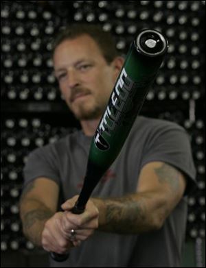 Dave Kidd, of Toledo Sports Equipment, lifts a Toledo brand Katana Dragon slow-pitch bat.