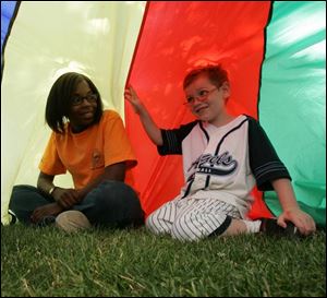 Ranger Tanesha Reed, 17, spends some time with 5-year-old Meguire Smith in Walbridge Park.