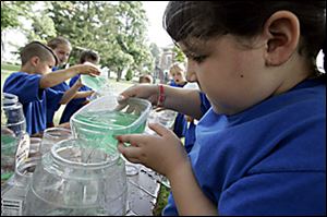Marissa Panos, 8, learns firsthand how diluting  a pollutant does not eliminate it in an excercise called 'Dilution Is Not the Solution.'
