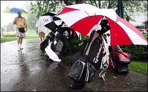 Clubs are left under cover as players head inside during a rain delay today at Highland Meadows Golf Club. Today's Pro-Am was cancelled. 