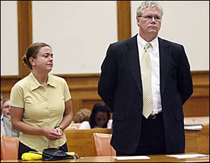 Nora Wallace, 33, of Toledo, and her attorney listen as Judge Denise Ann Dartt addresses her during her sentencing for embezzling more than $65,000 while she was employed at the Lucas County Jail from December through May. Wallace, who stole the money to pay bills and buy drugs, was given probation and was ordered to make restitution.