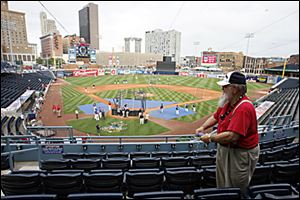 Ross Carr, 72, an usher at Fifth Third Field, cleans seats from yesterday's rain as the teams prepare for last night's Triple-A All-Star Game.