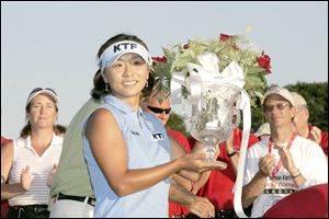 Mi Hyun Kim shows the trophy she won after beating Natalie Gulbis in a sudden-death playoff to win the Jamie Farr Classic.