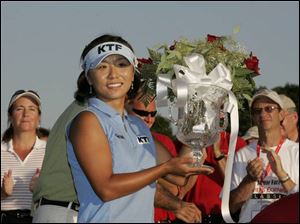 South Korean golfer Mi Hyun Kim holds the trophy for winning the Jamie Farr Owens Corning Classic presented by Kroger. She won in a playoff after rallying late to tie Natalie Gulbis.