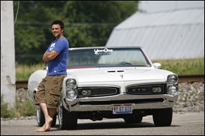 Eric Rychener strikes a confident pose with his 1967 Pontiac LeMans, which he transformed into a GTO model .