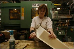 Ann Norrick works on a plastic tray that will be part of a sewing table at the Manta-Ray Inc. plant in West Unity, Ohio. The plant makes a variety of injection-molding products. 