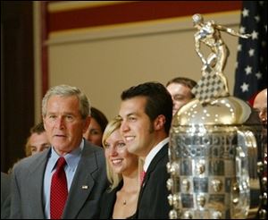 President Bush with Sam Hornish Jr., right, winner of the 2006 Indianapolis 500, and his wife Crystal Hornish, as they stand next to the Borg-Warner Trophy at the Eisenhower Executive Office Building at the White House today.