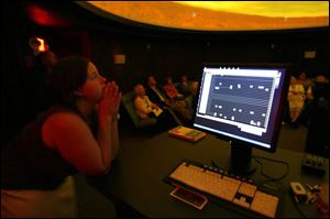 Erika Buri, the new planetarium coordinator at Lourdes College, conducts a demonstration of the facility's new computerized video projector. The planetarium had been closed since 1999.