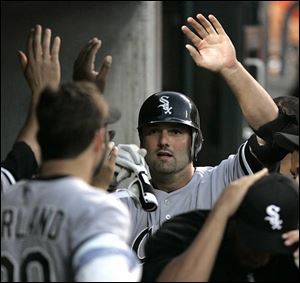 Chicago's Paul Konerko is greeted by teammates after his second home run of the game, a three-run shot in the seventh.