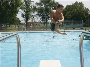 Zach Reiner, 8, does a cannonball into the community pool in Delta.